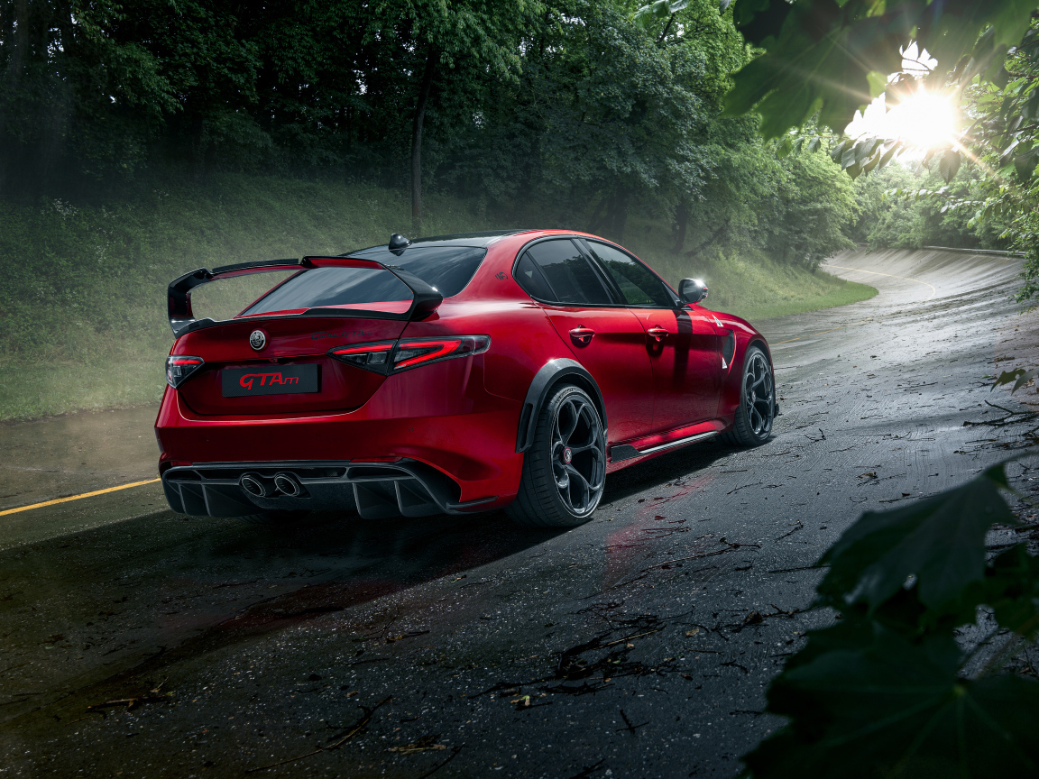 Красный автомобиль Alfa Romeo Giulia GTAm, 2021 года на дороге в лесу