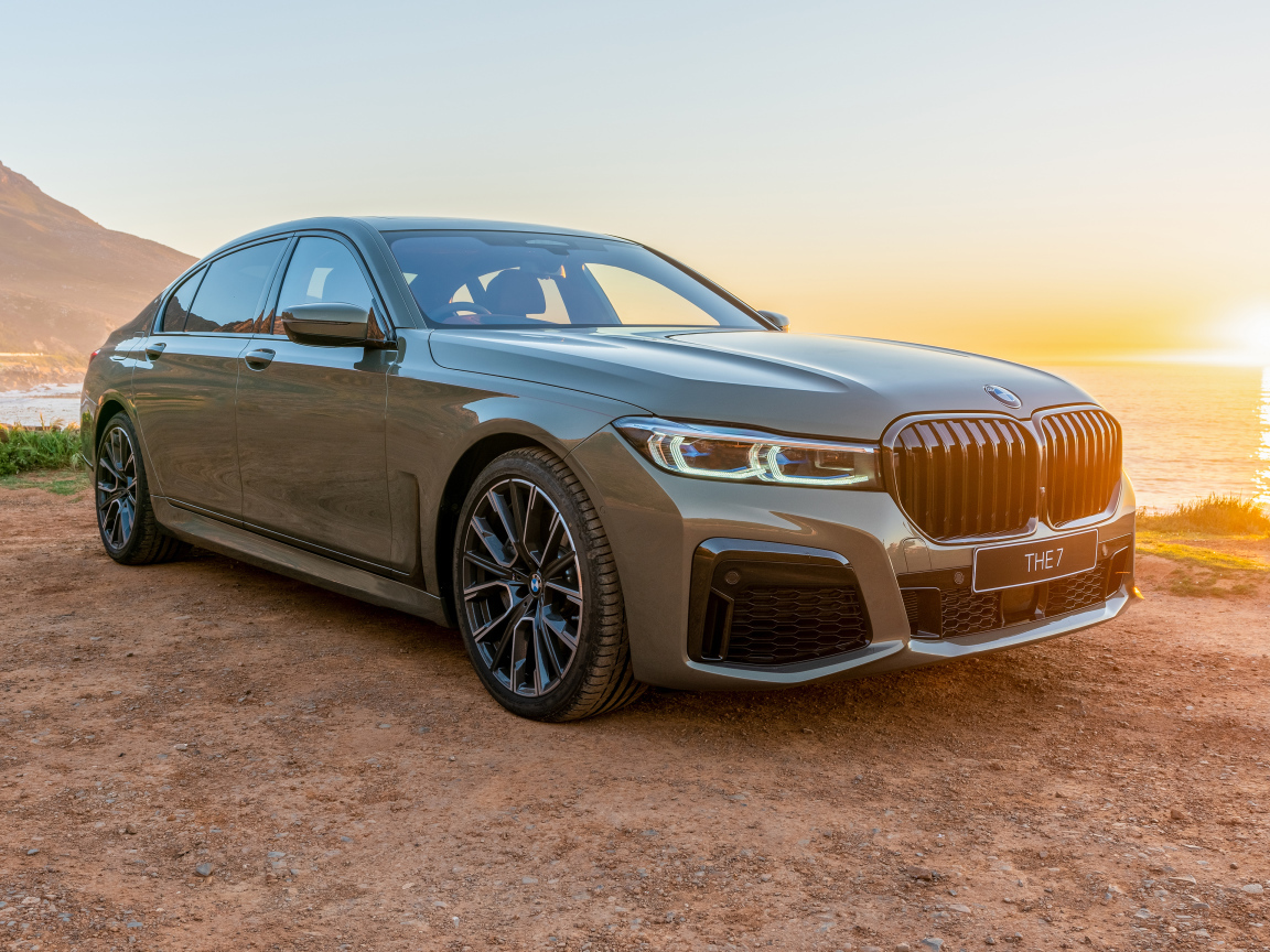 Стильный дорогой автомобиль BMW 745Le , 2020 года на фоне заката