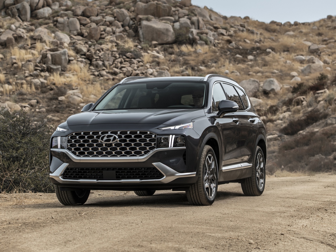 Черный автомобиль  Hyundai Santa Fe Hybrid, 2021 года у камней