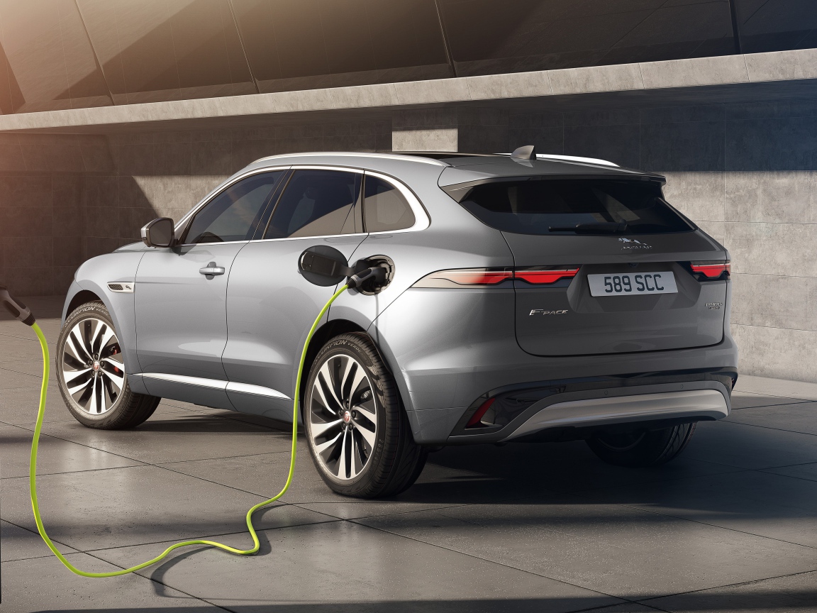 Серебристый автомобиль Jaguar F-Pace P400e AWD 2020 года на заправке 