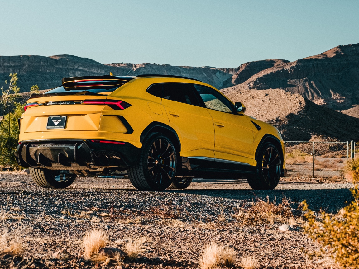 Желтый автомобиль Lamborghini Urus 2019 года в горах 