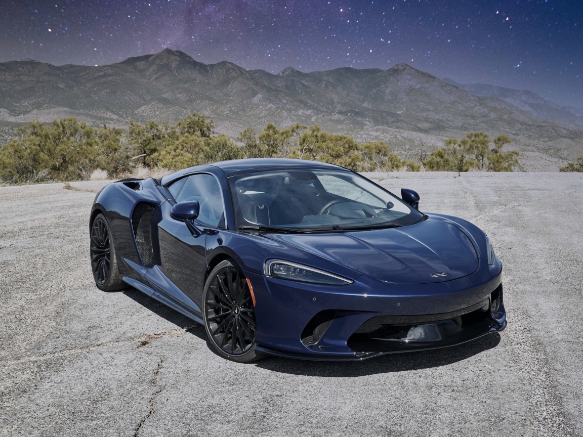 Черный автомобиль  McLaren GT, 2020 года под звездным небом