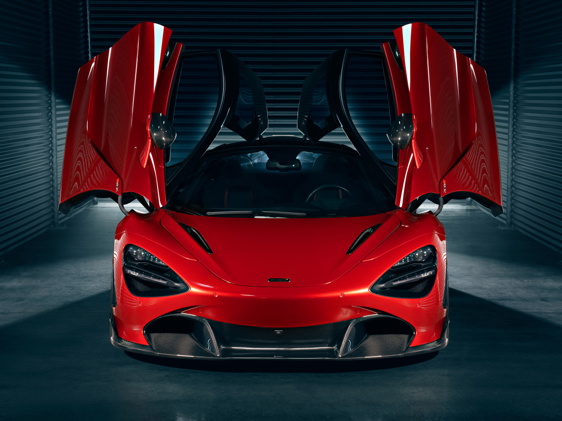Красный автомобиль McLaren 720S с открытыми дверями в гараже