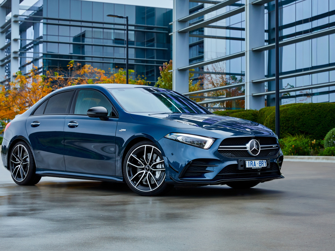 Синий автомобиль Mercedes-Benz AMG A 35, 2020 года на фоне здания 