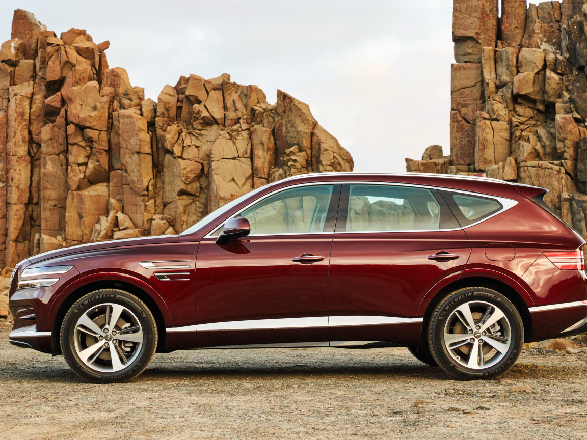 Бордовый автомобиль Genesis GV80 2.5T 2020 года на фоне гор