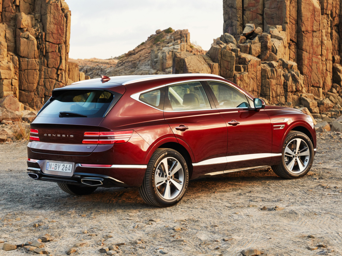 Красный автомобиль Genesis GV80 2.5T 2020 года на фоне гор