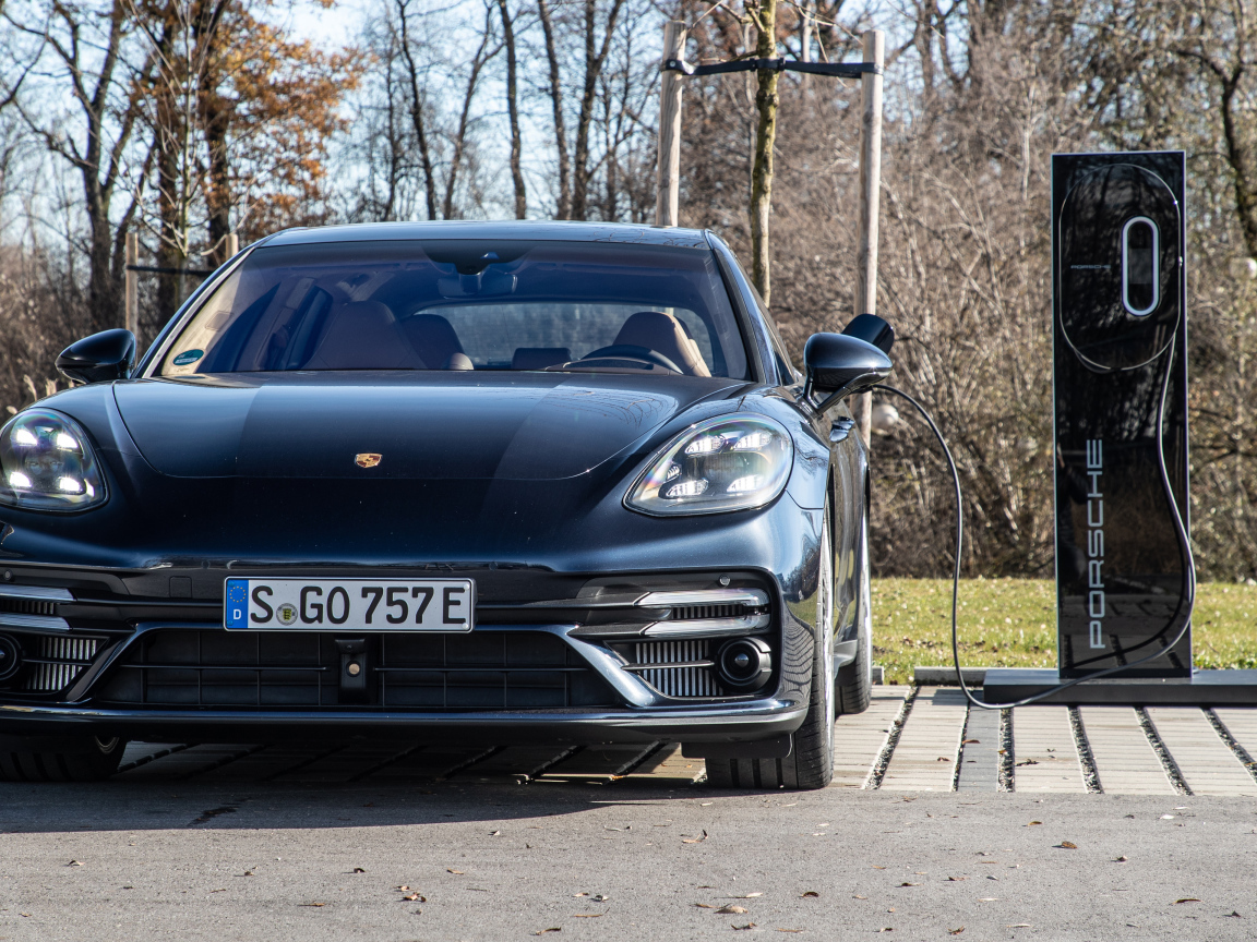 Черный автомобиль Porsche Panamera Turbo S E-Hybrid Sport Turismo 2021 года на заправке