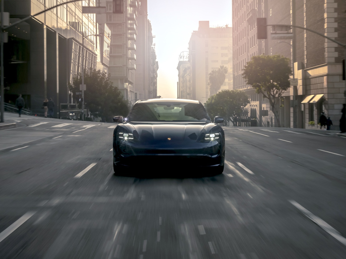Черный стильный автомобиль  Porsche Taycan Turbo, 2020 года на дороге в городе