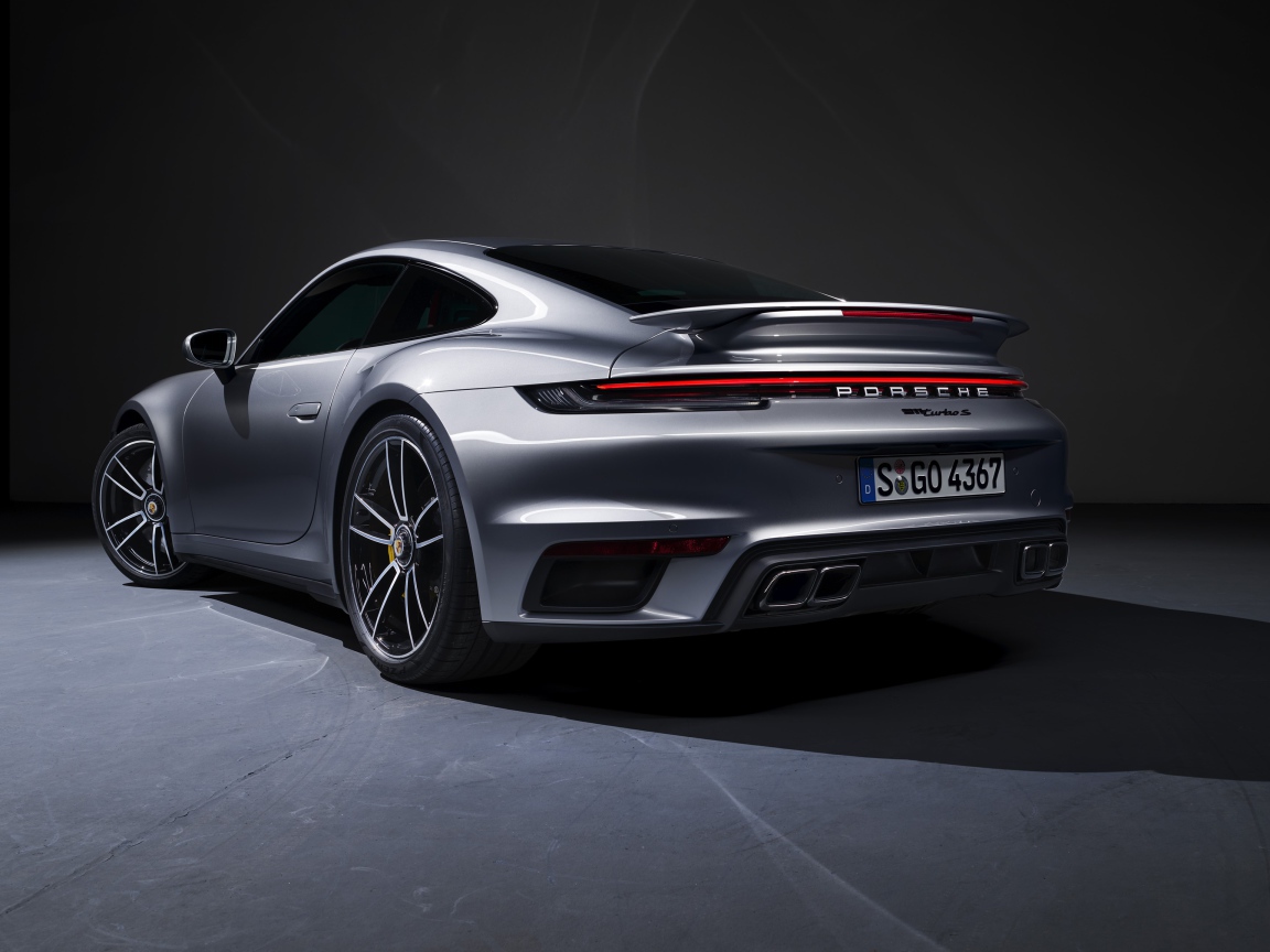 Серебристый автомобиль Porsche 911 Turbo S 2020 года вид сзади