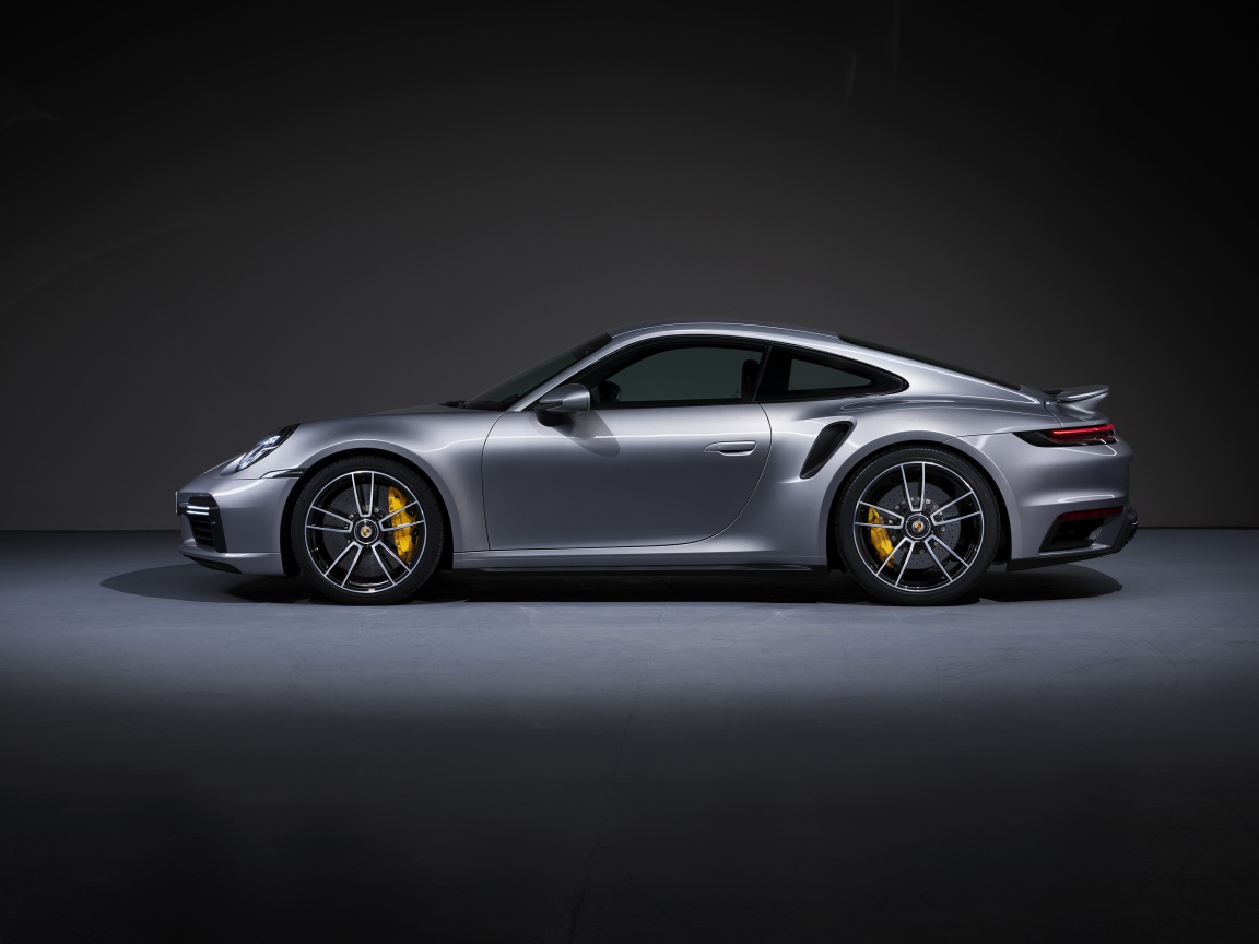 Серебристый автомобиль Porsche 911 Turbo S 2020 года вид сбоку 