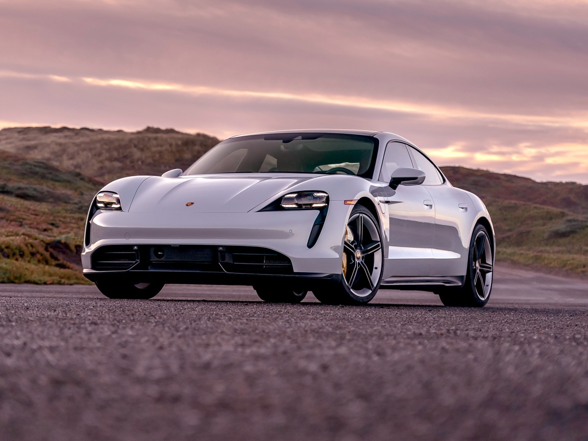 Серебристый автомобиль Porsche Taycan Turbo S 2020 года на фоне неба