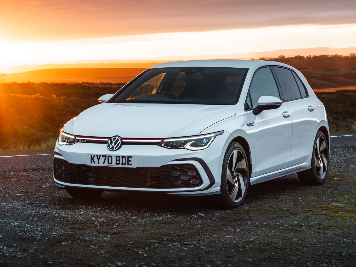 Белый автомобиль Volkswagen Golf GTI 2020 года на закате солнца