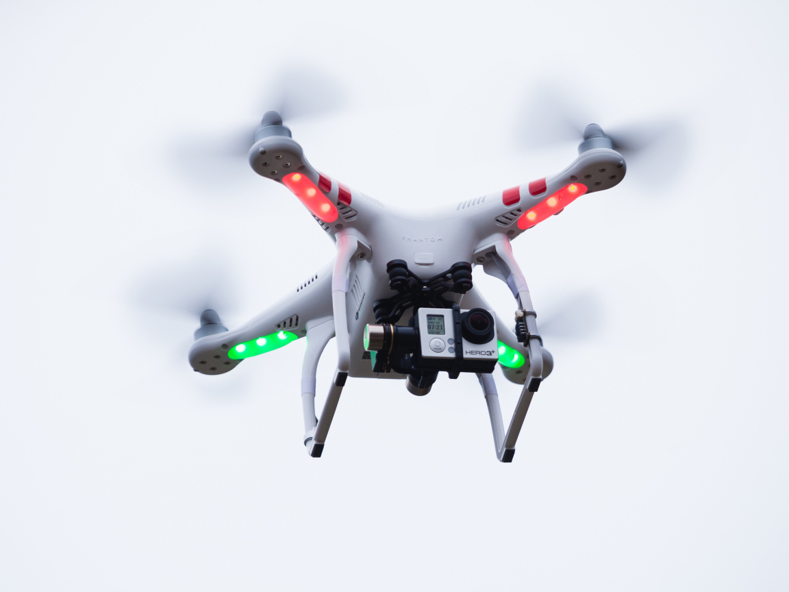 Квадрокоптер с видеокамерой на белом фоне