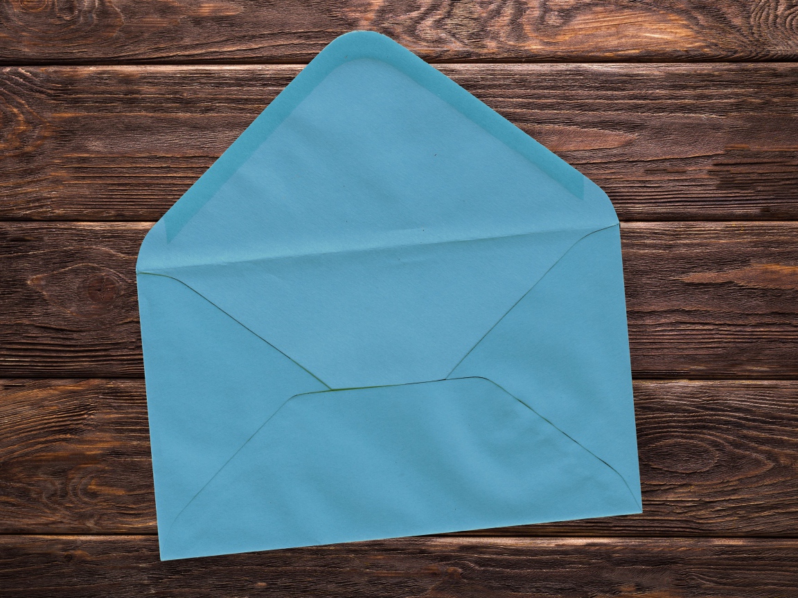 Голубой бумажный конверт на деревянном фоне