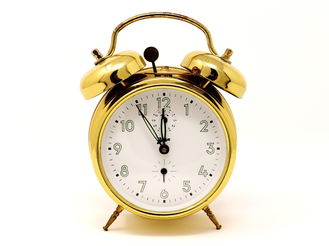 Золотой будильник на белом фоне 