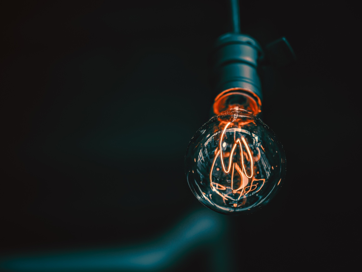 Зажженная лампа накаливания под потолком