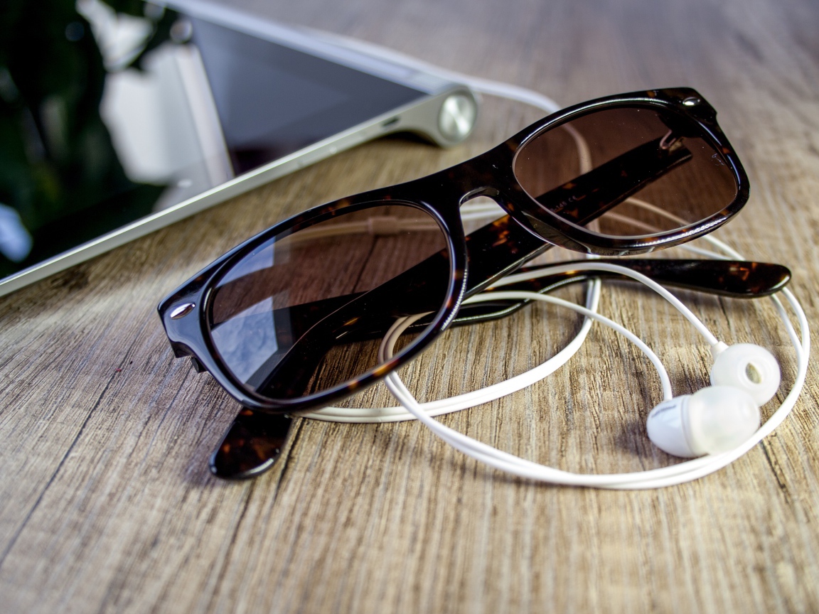 Солнечные очки с наушниками на столе
