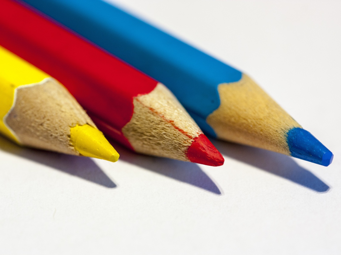 Три разноцветных карандаша на белом фоне
