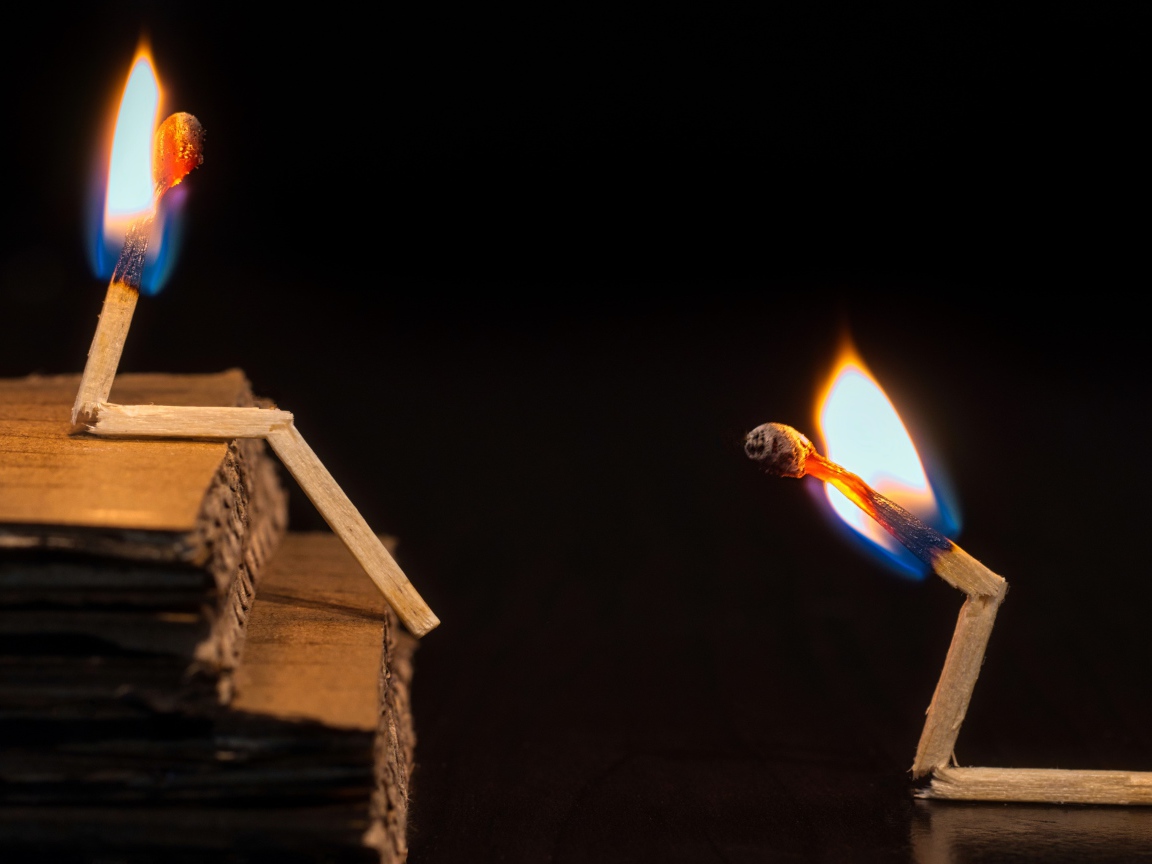 Две горящие спички на черном фоне 