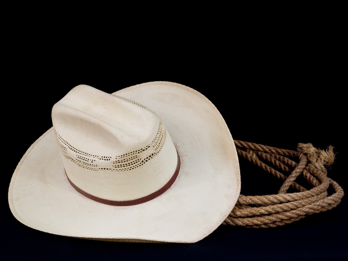 Белая ковбойская шляпа с лассо на черном фоне