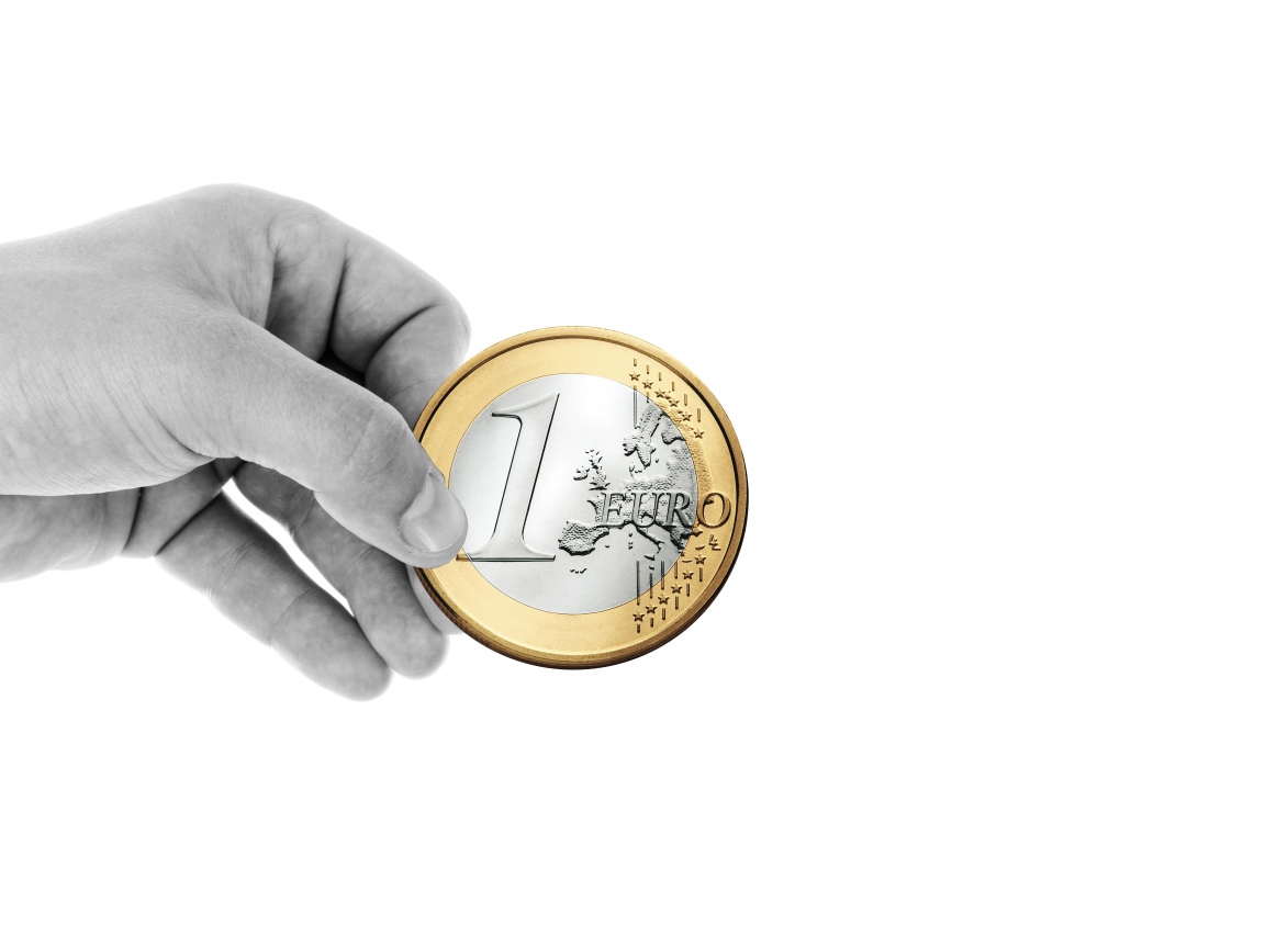 One euro coin in hand on a white background