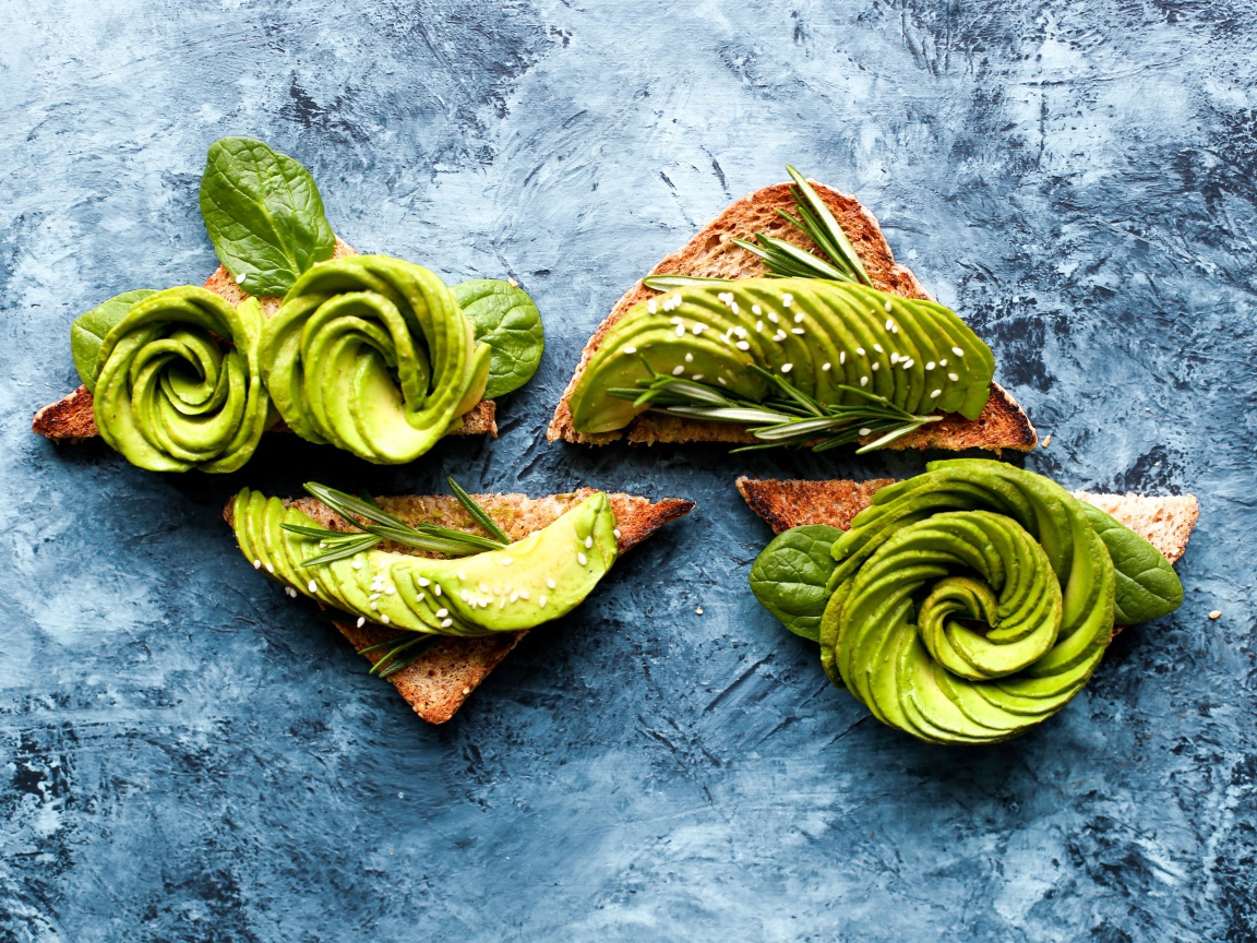 Хлеб с авокадо и базиликом на столе 