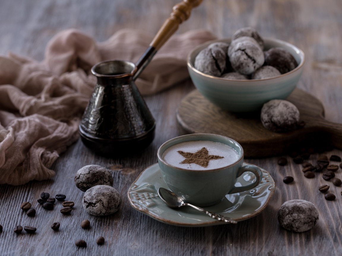 Чашка кофе на столе с пряниками и зернами