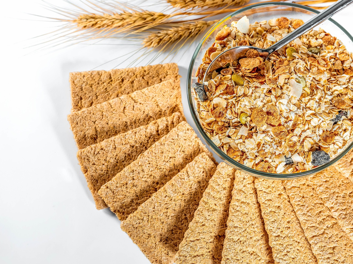 Мюсли в тарелке на столе с хлебцами 