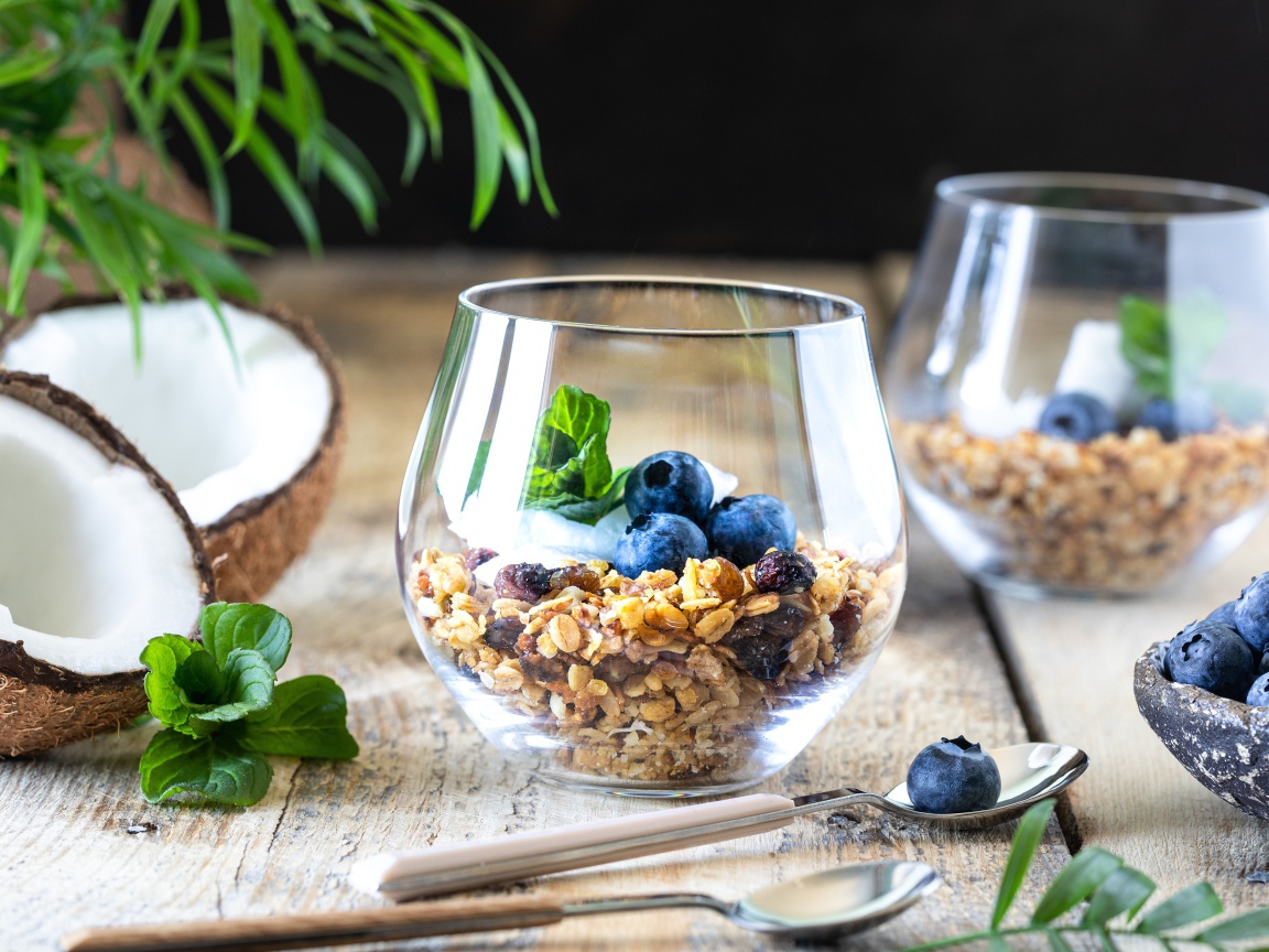 Мюсли с ягодами черники на столе с кокосом