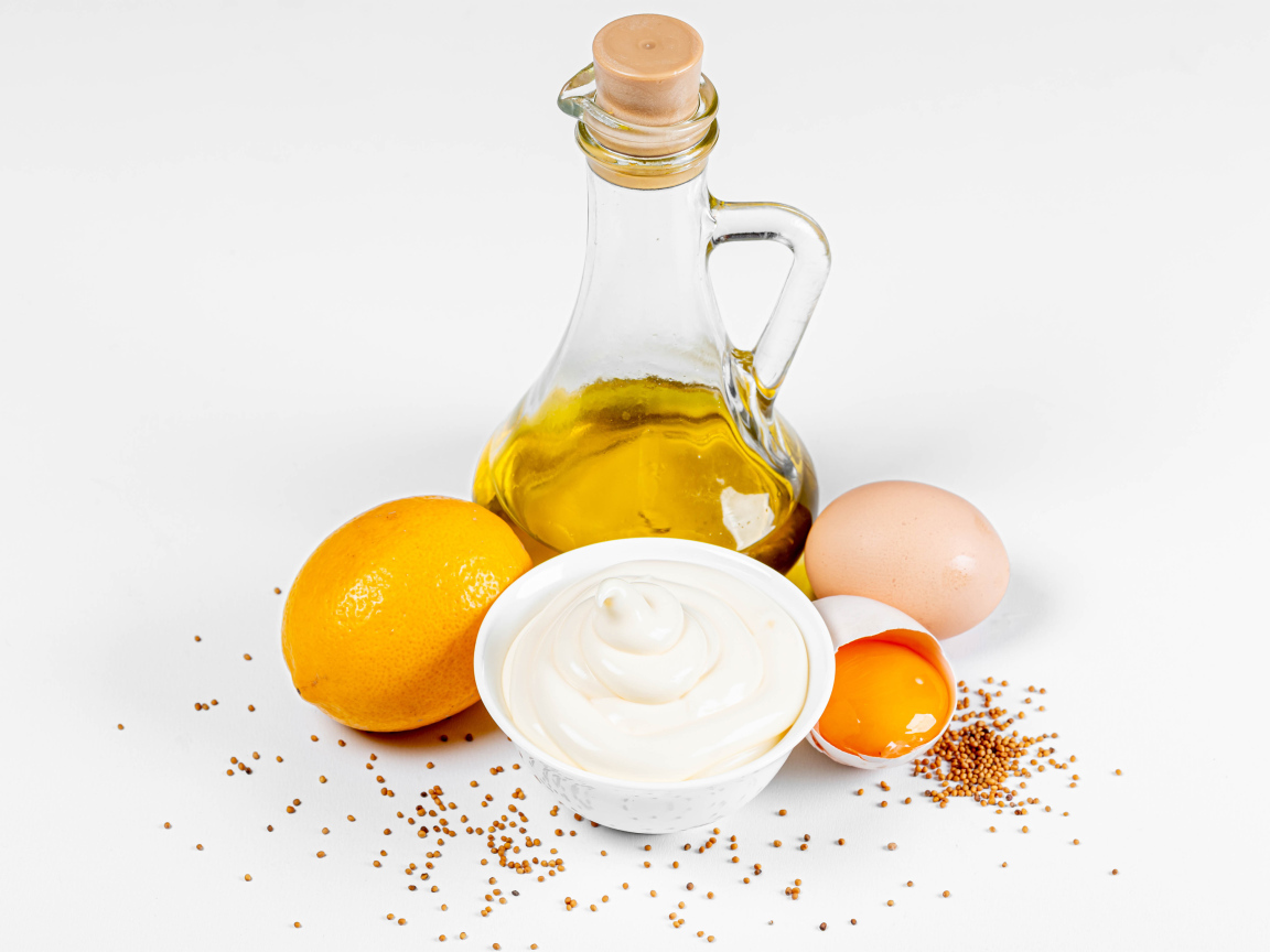 Оливковое масло, яйца и лимон на белом фоне с майонезом