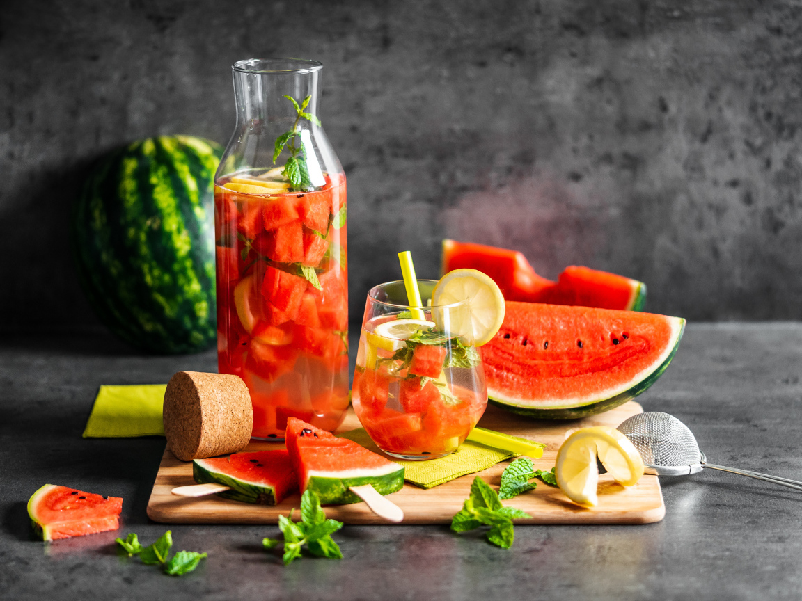 Вкусный напиток на столе с кусочками арбуза 