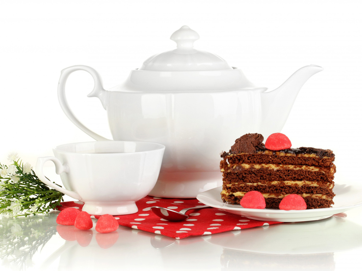 Белая чашка чая и чайник на столе с куском торта