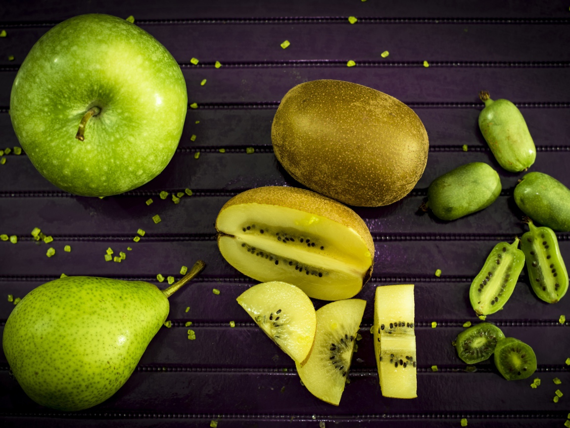 Зеленое яблоко на столе с грушей, киви и фейхоа 