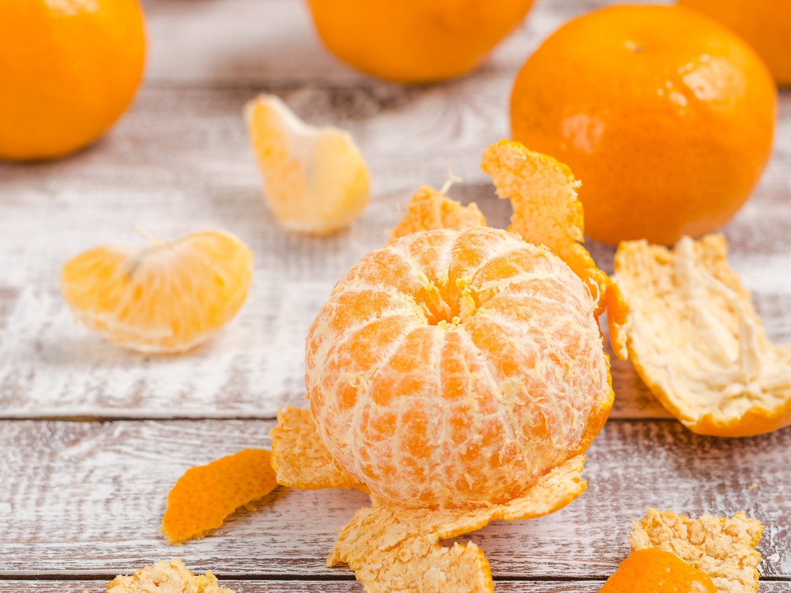 Очищенный мандарин на деревянном столе 