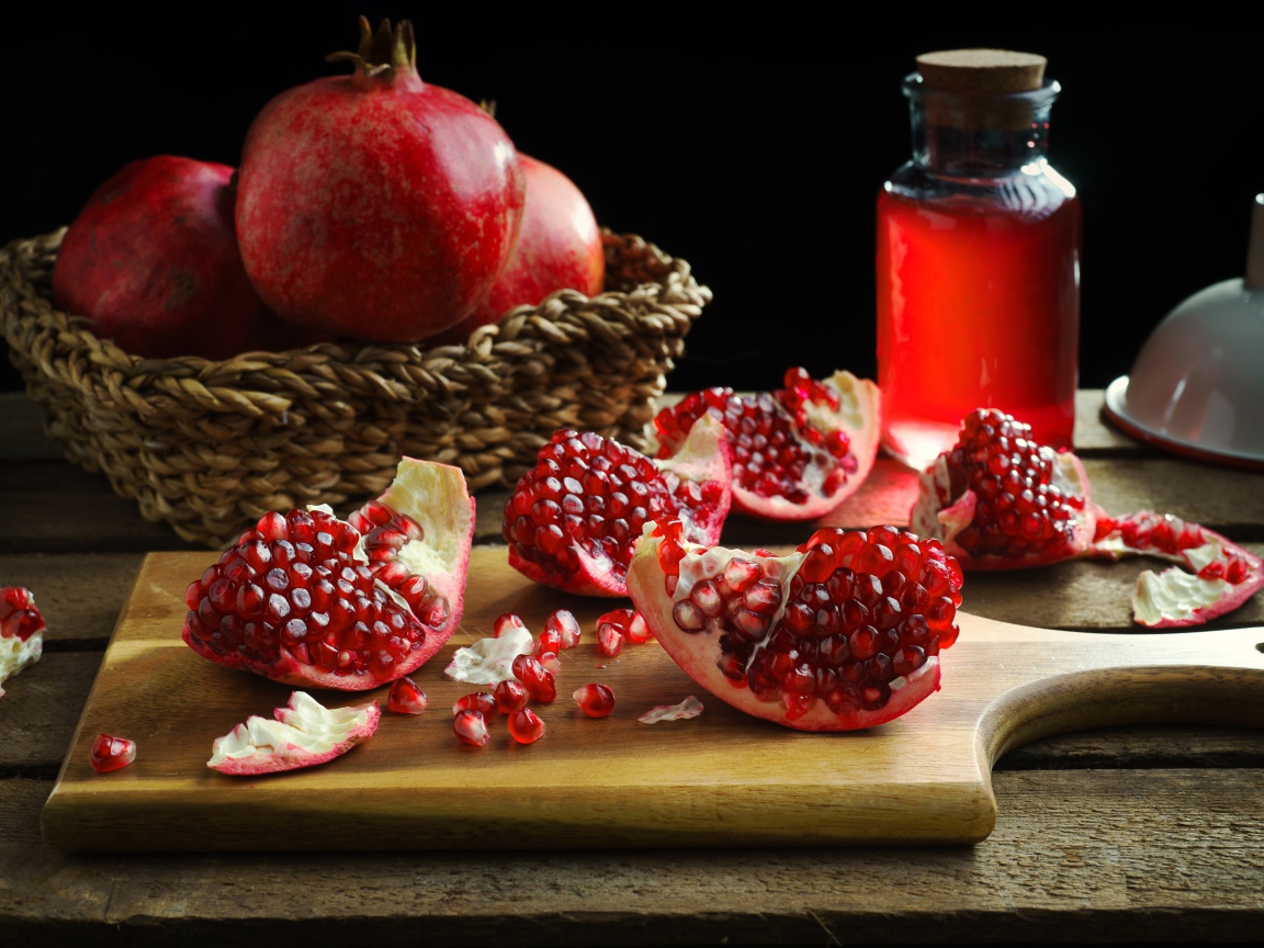 Плоды граната на столе с соком 