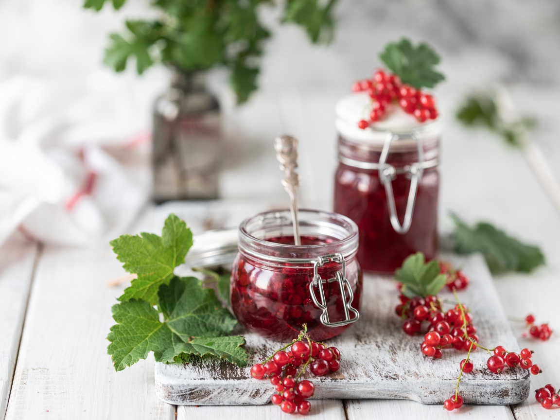 Варенье из красной смородины на столе со свежими ягодами
