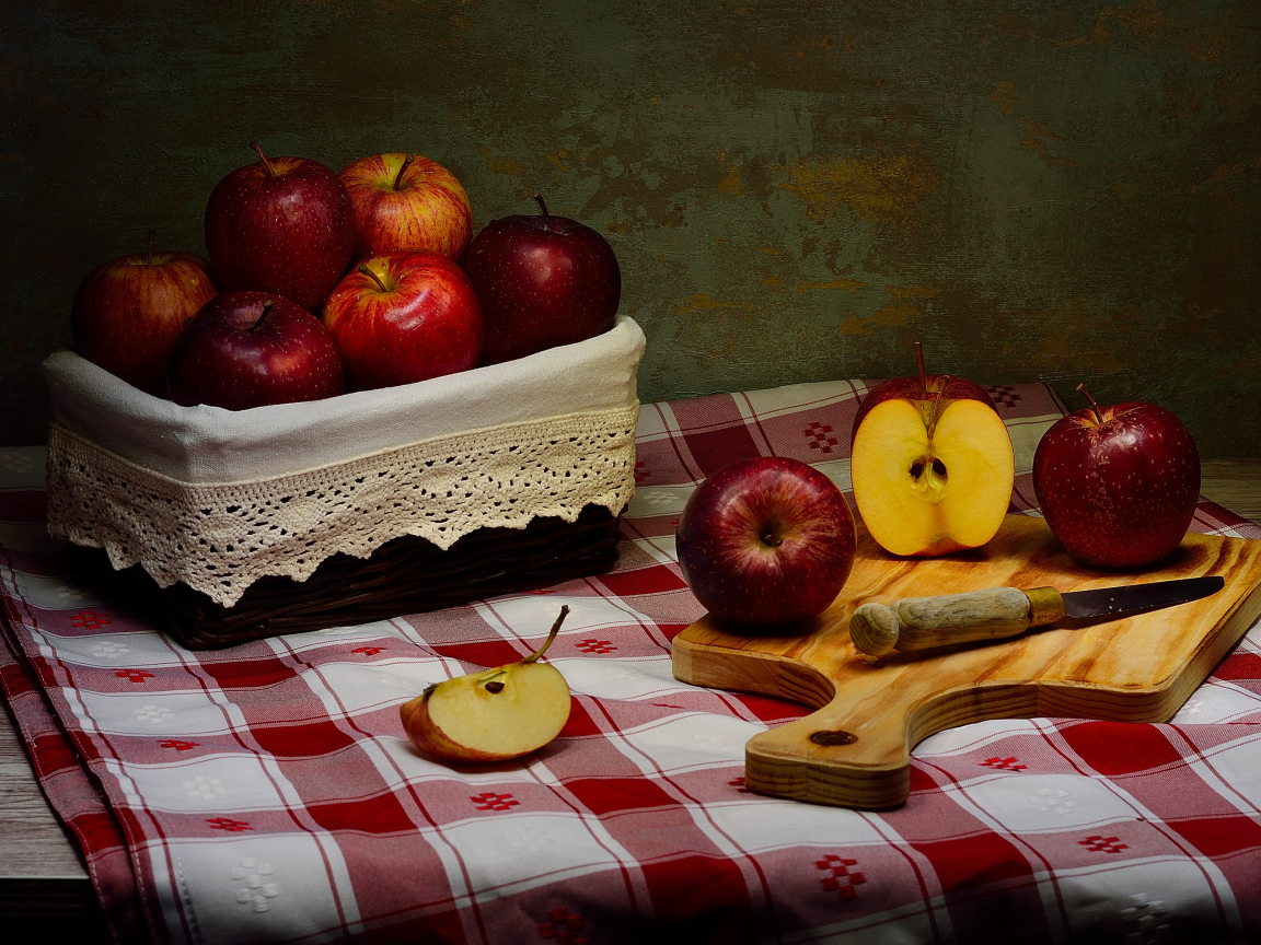 Спелые красные яблоки на столе с ножом