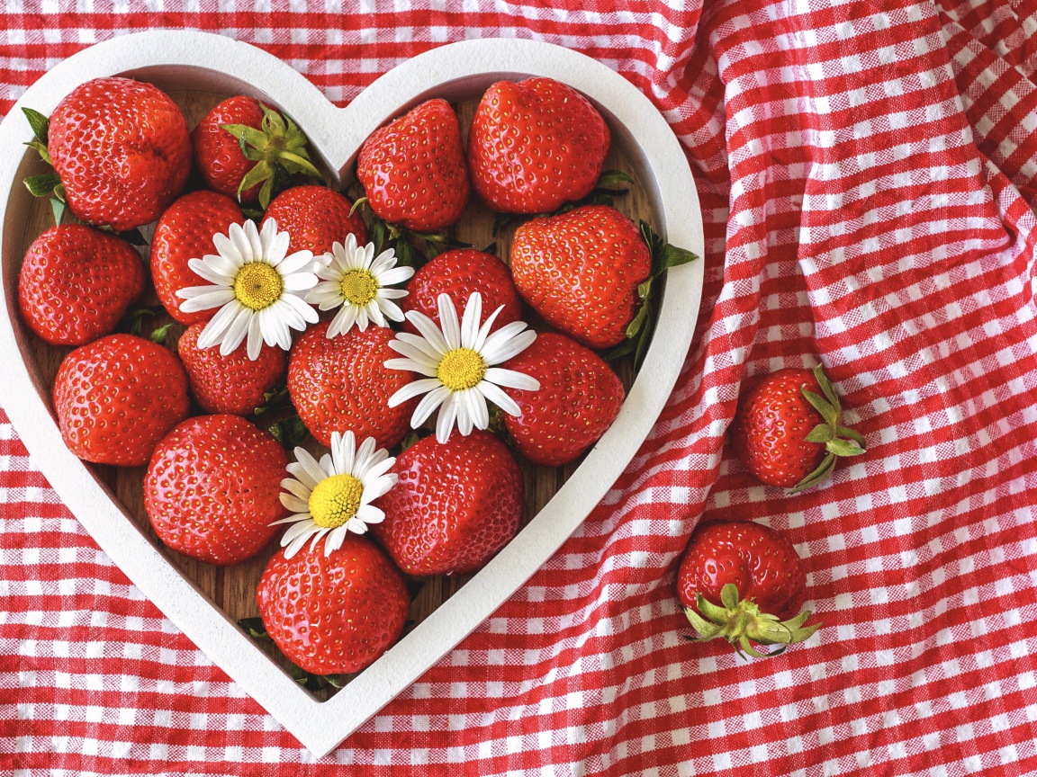 Спелая красная клубника в коробке в форме сердца с ромашками
