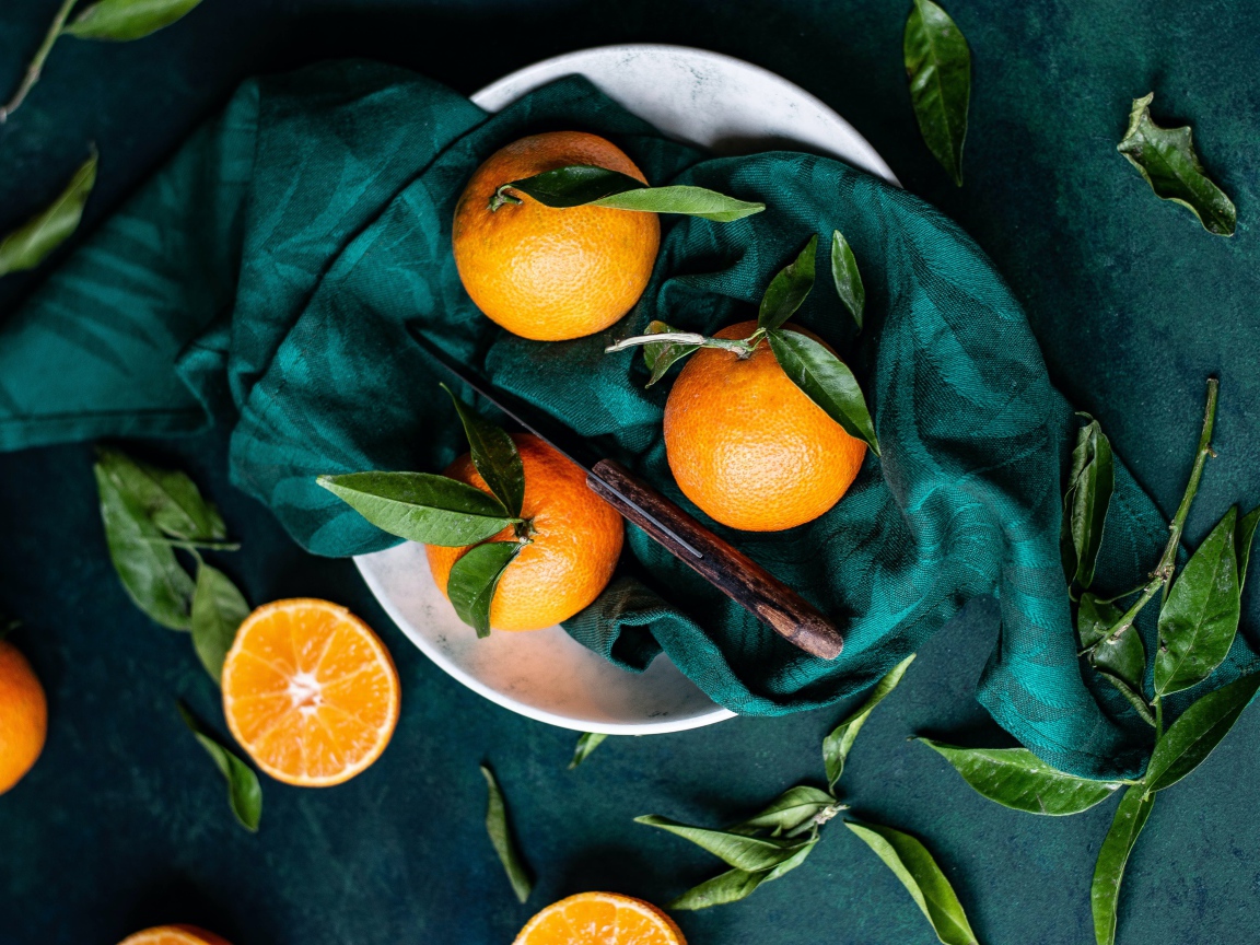 Спелые мандарины на столе в платком 