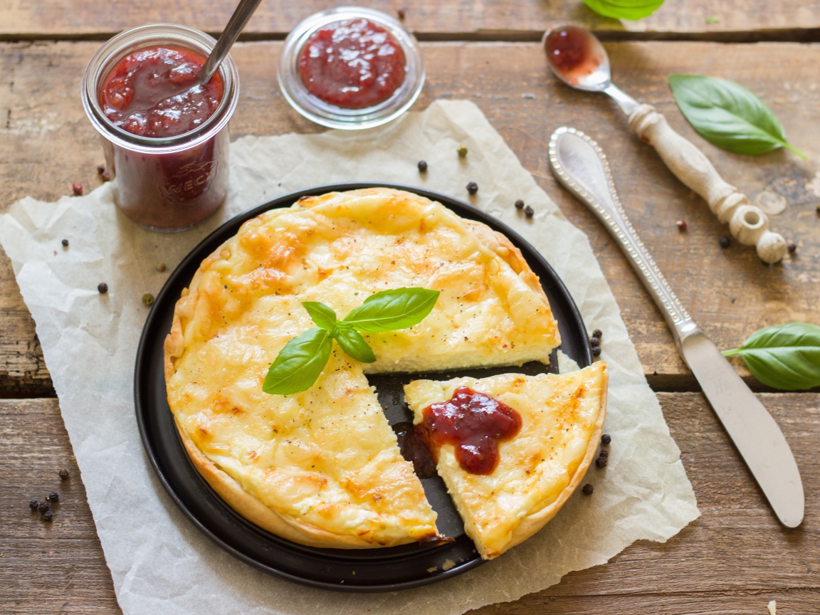 Пирог с сыром на столе с кетчупом и базиликом