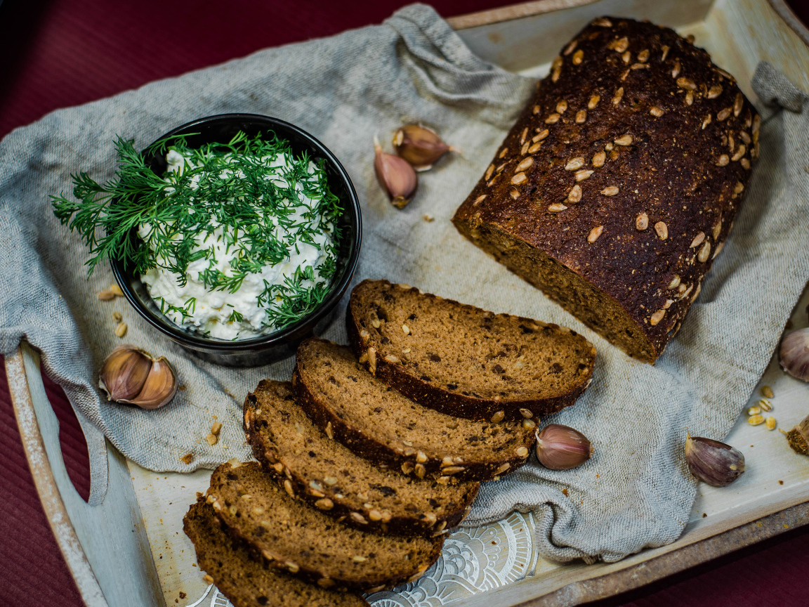 Свежий хлеб с зернами на столе с соусом и чесноком