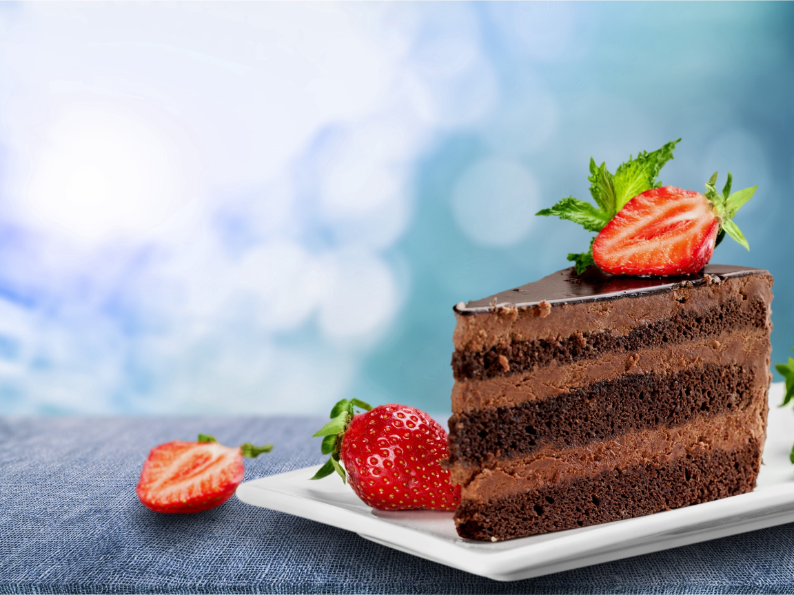 Кусок аппетитного торта с шоколадным кремом и клубникой 