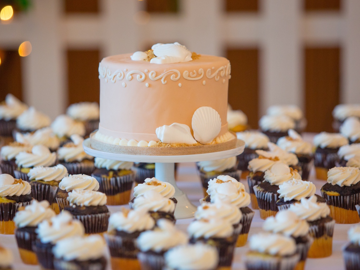 Праздничный торт с пирожными на столе 