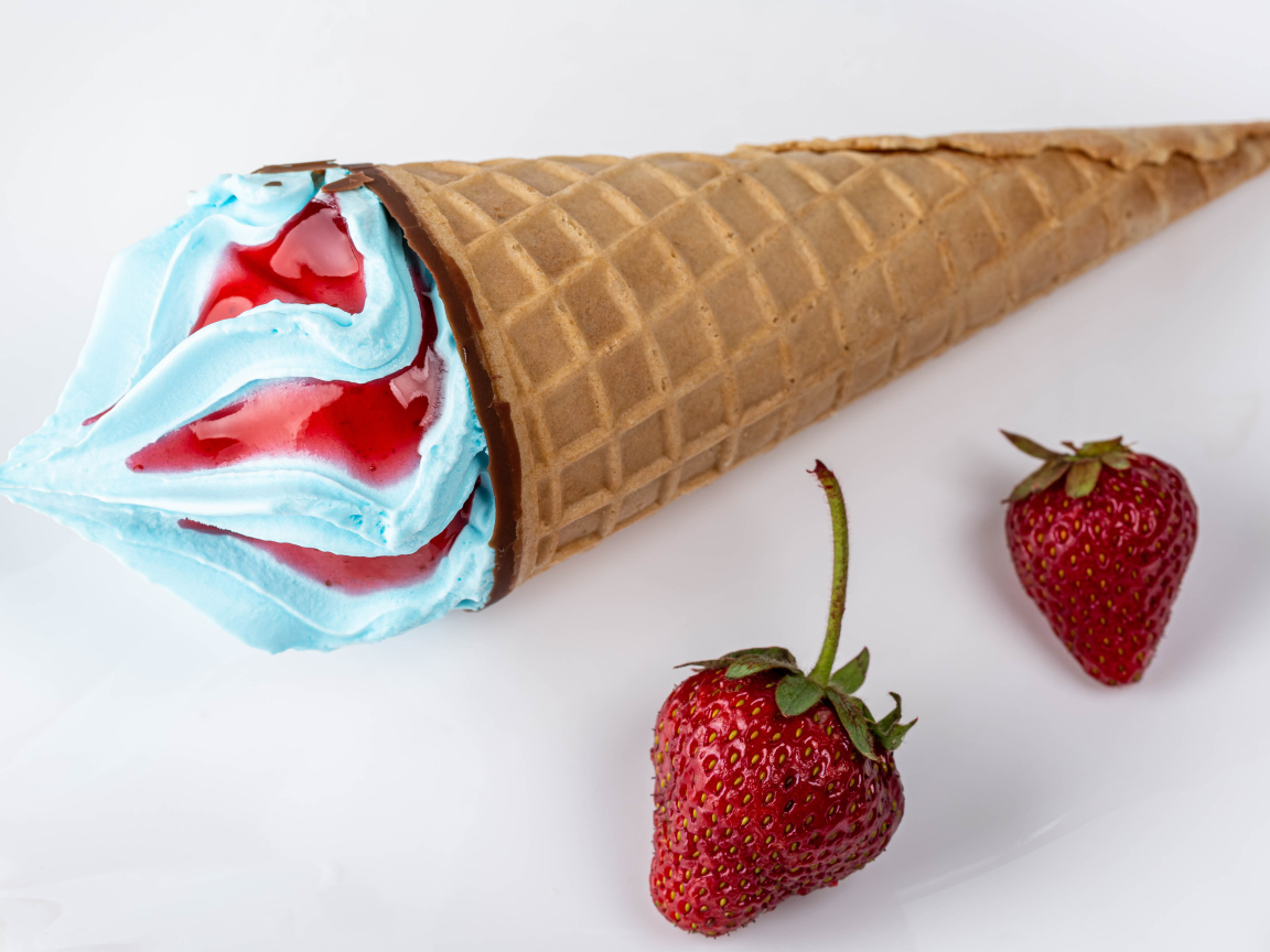 Рожок с голубым мороженым на сером фоне с клубникой 