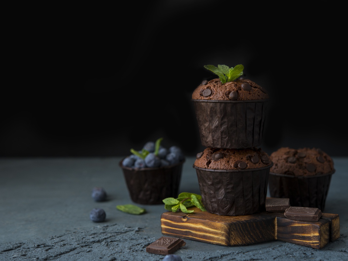 Кексы с шоколадом на столе с ягодами черники на столе 