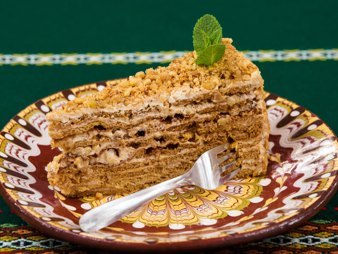 Вкусный медовый торт с орехами на красивой тарелке 