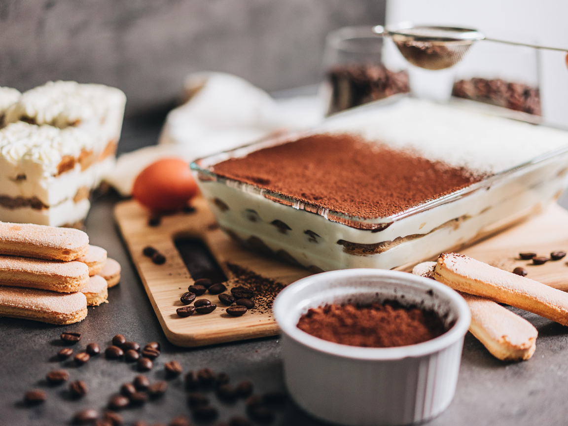 Десерт тирамису на столе с какао 