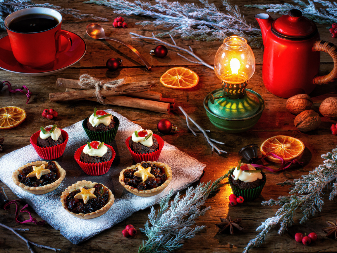 Разные кексы на столе с лампой и кофе