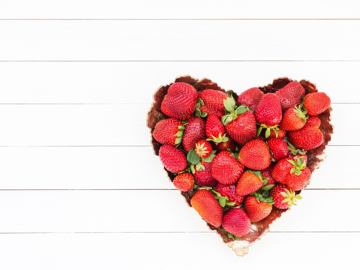 Пирожное в форме сердца с клубникой на белом фоне