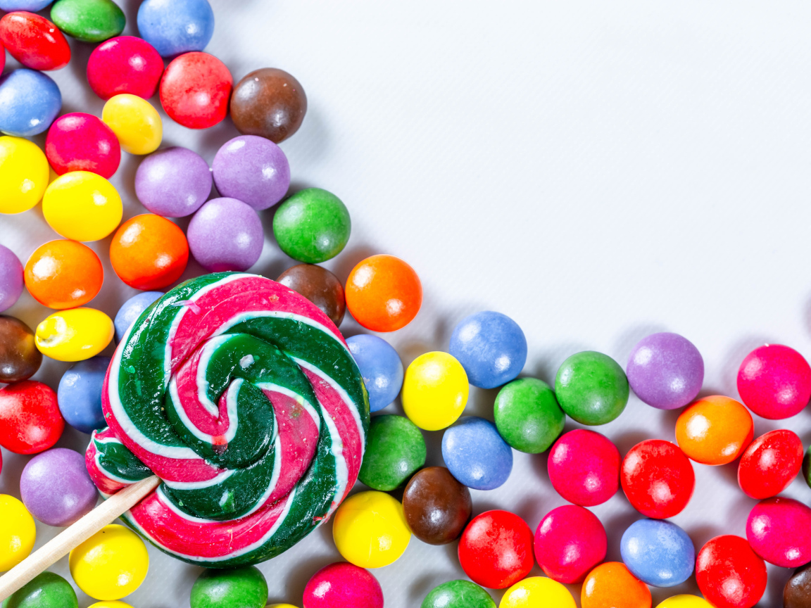 Разноцветные конфеты в глазури и карамель на белом фоне 